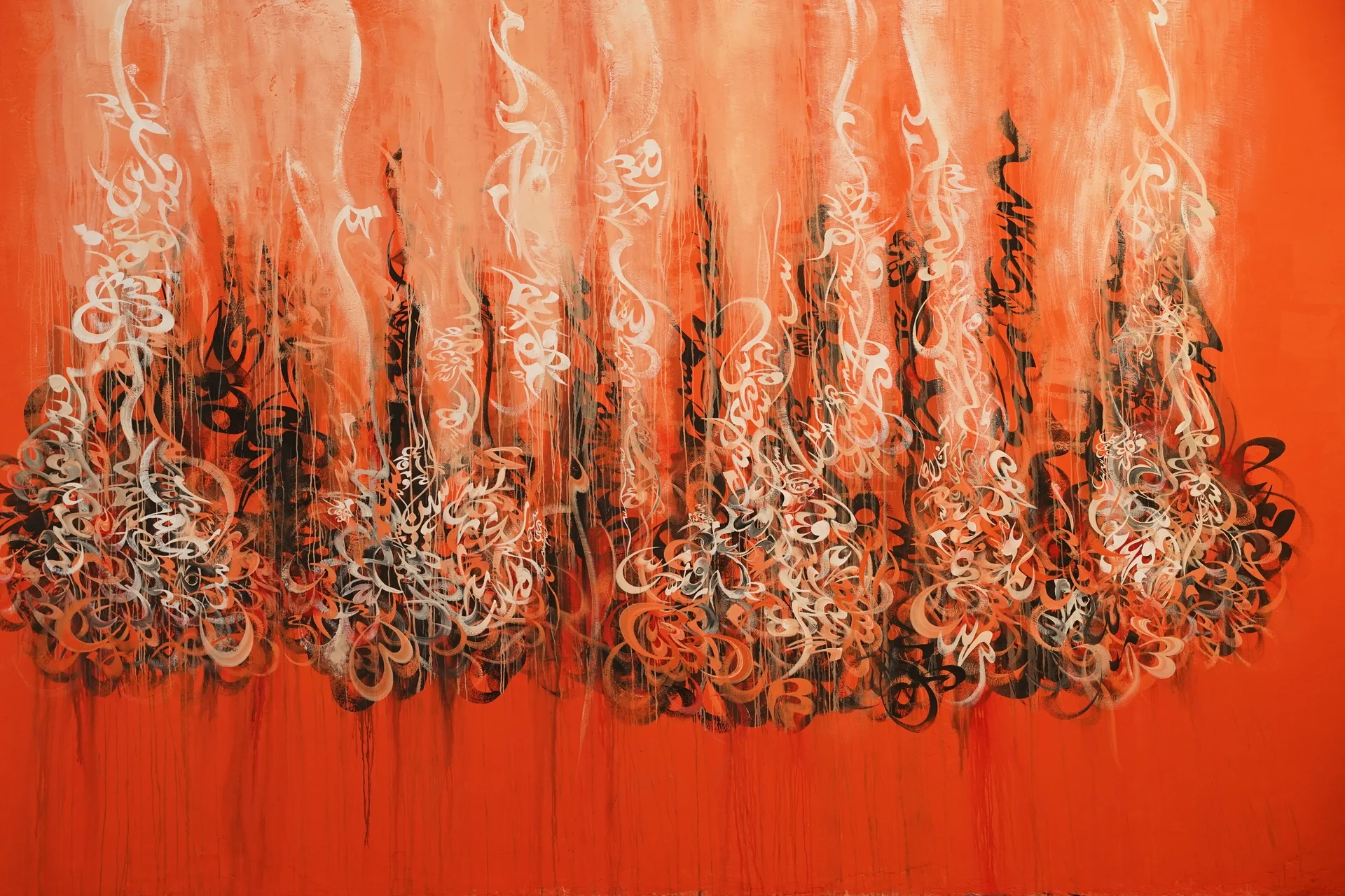 Mural of Arabic calligraphy on an orange background, painted on a wall in Asilah