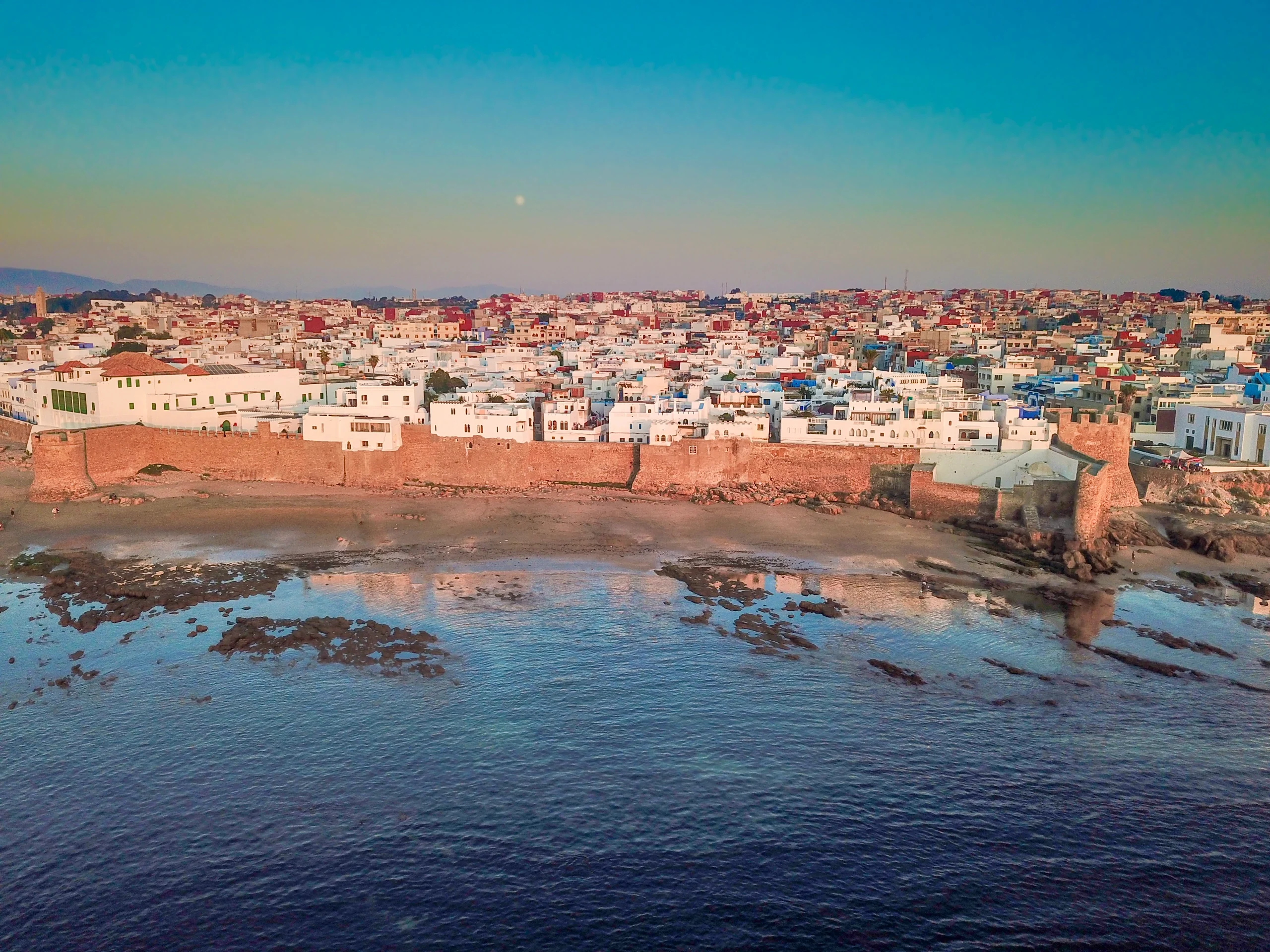 Aerial view of the walls and white houses of Asilah by the sea