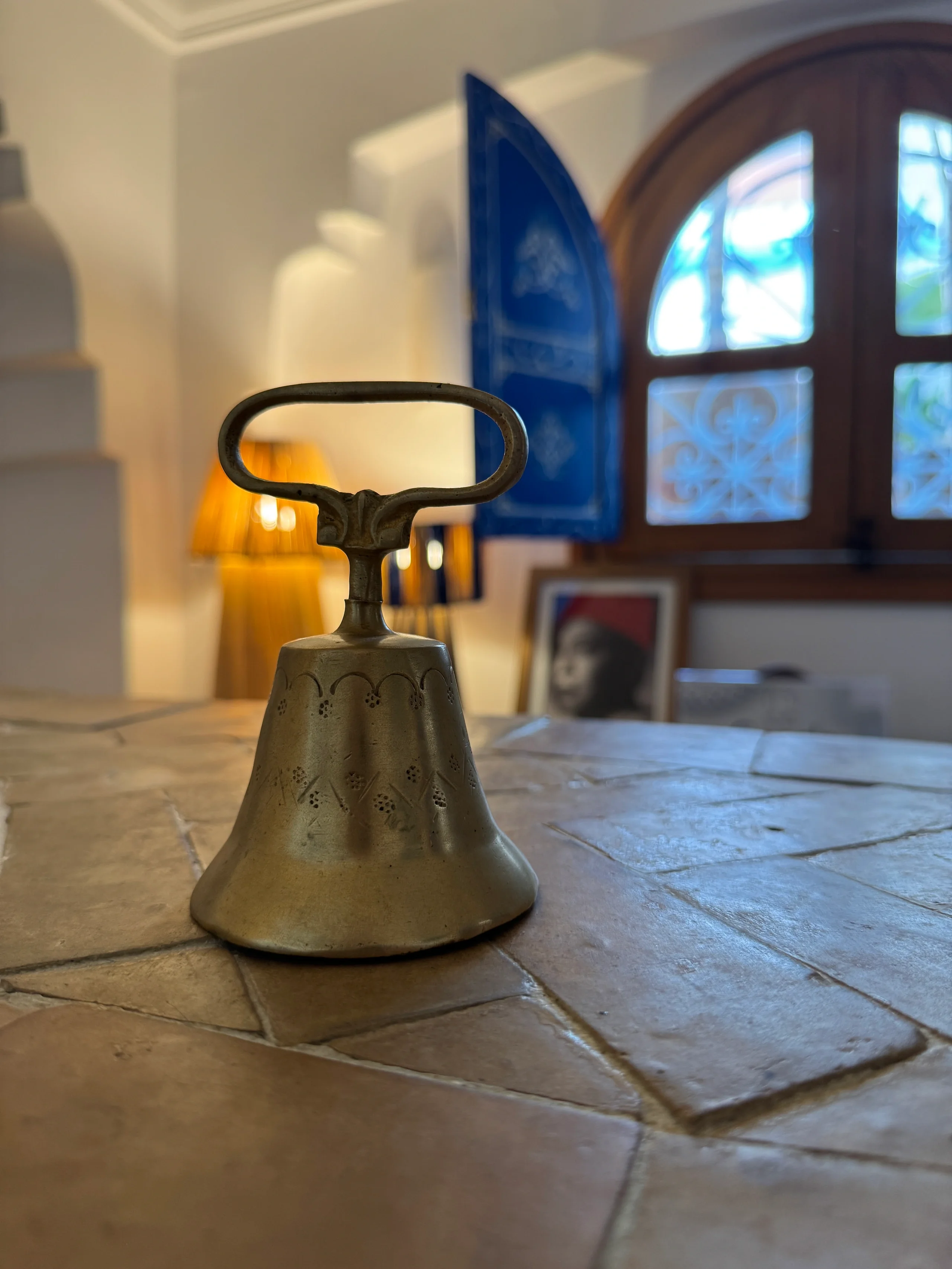 Campanilla de latón sobre una mesa de baldosas