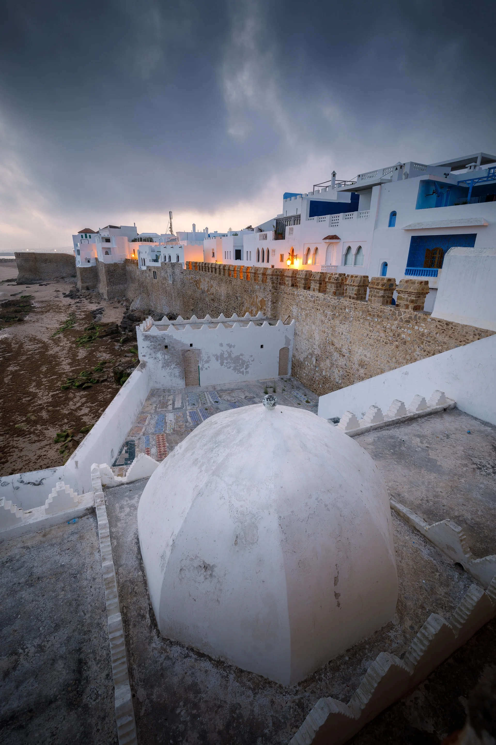 White dome of the Sidi Ahmed El Mansur mausoleum beside the walls at dusk