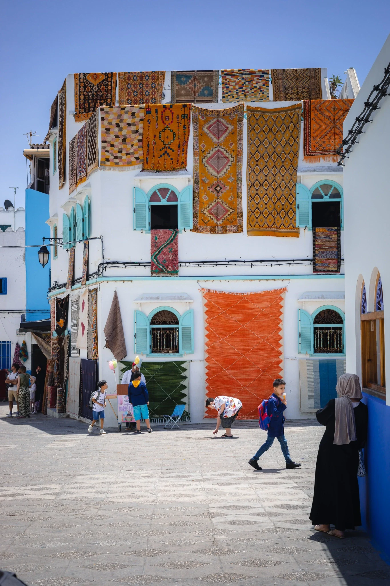 Traditional rugs hanging on the facade of a house in Asilah