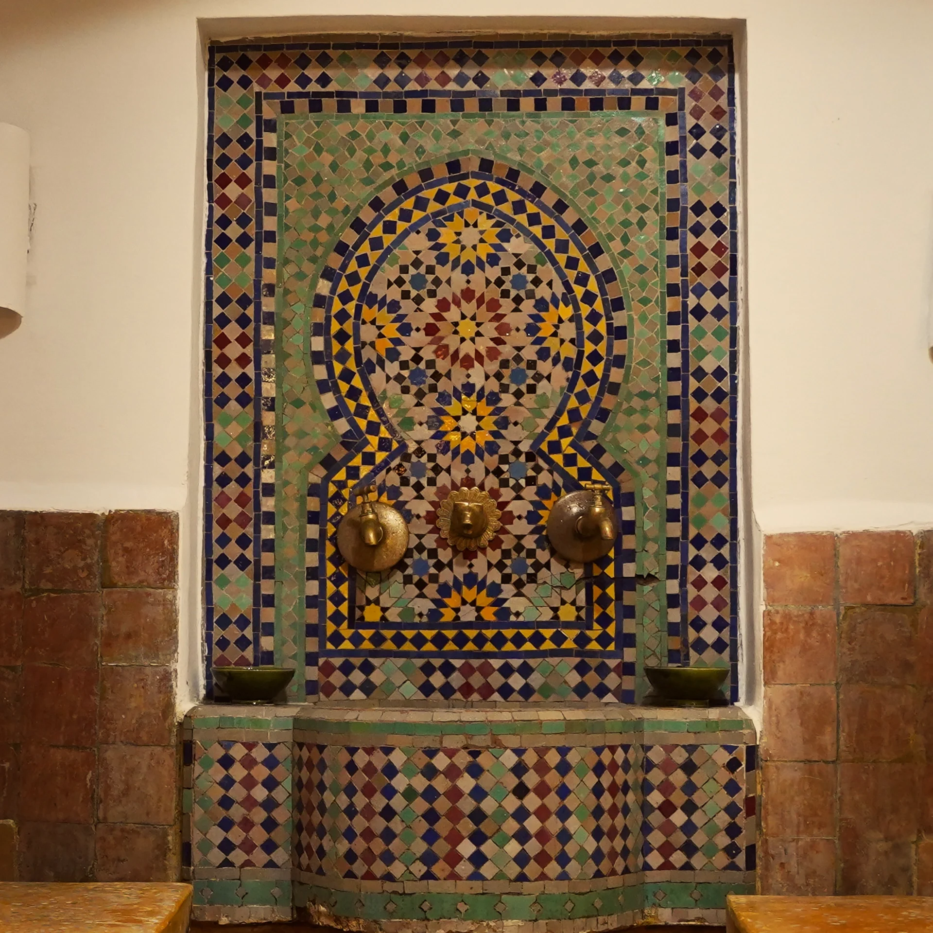 Fuente de mosaico de azulejos marroquíes con grifos de latón
